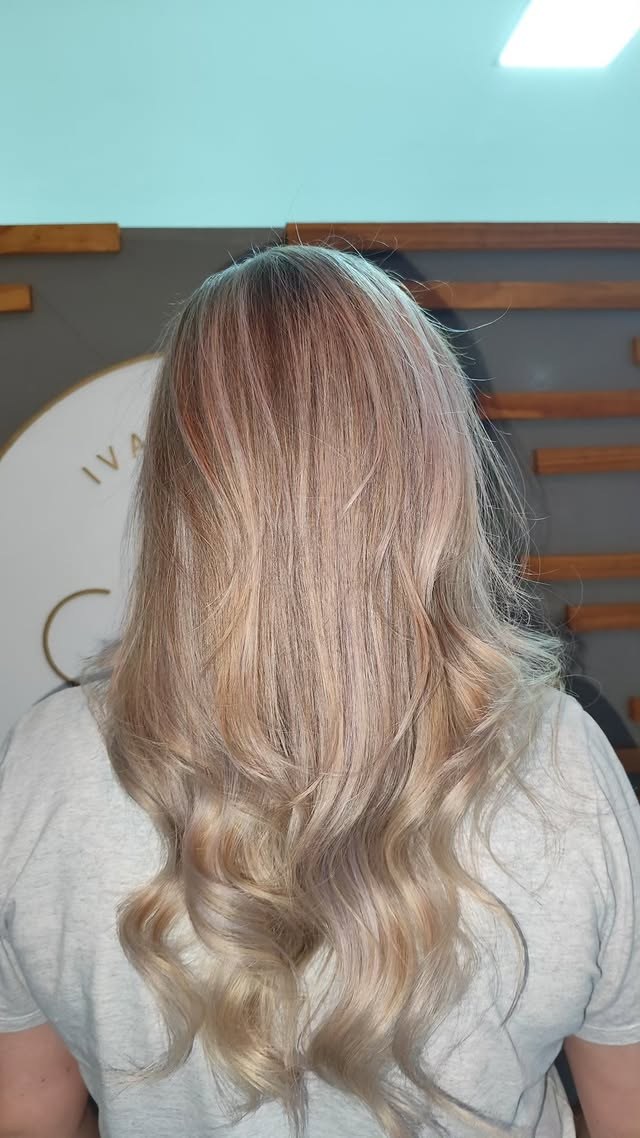 Coloração loira platinada com caimento em ondas suaves no Ivani Mello Studio de Beleza