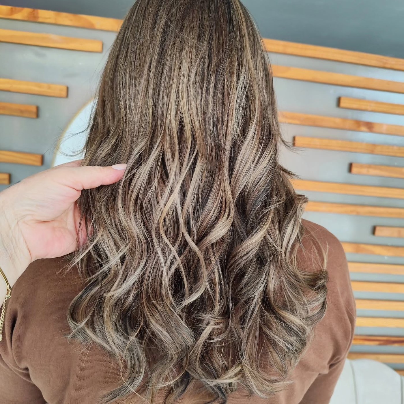 Mechas ash blonde em cabelo ondulado finalizado no Ivani Mello Studio de Beleza
