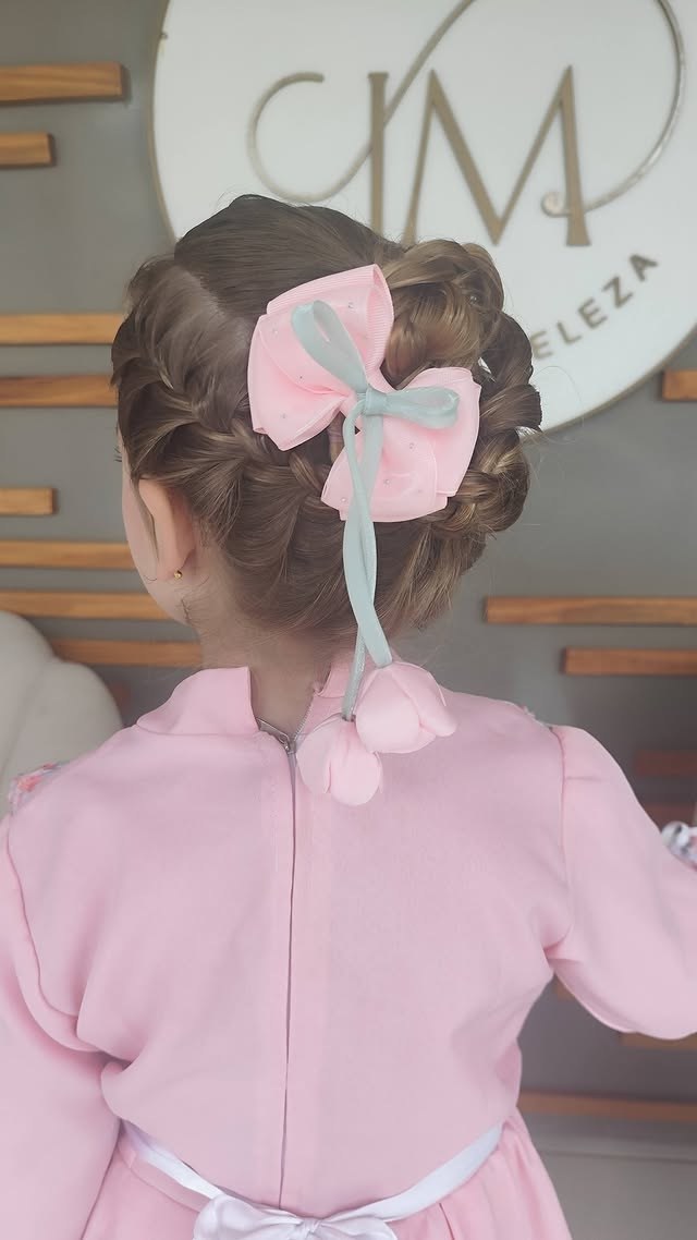 Penteado infantil com laço rosa para menina em vestido rosa